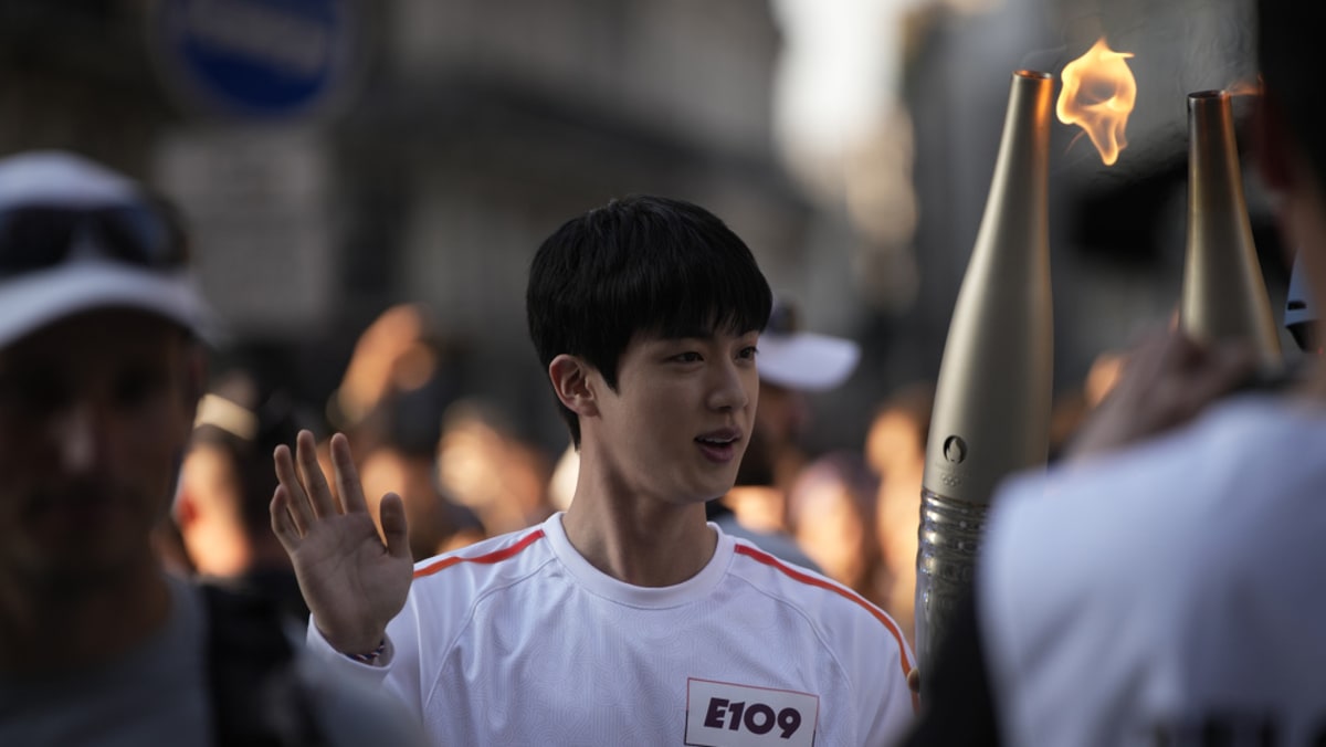 BTS member Jin carries Olympic torch in Paris near Louvre Museum